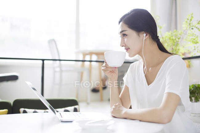 Donna cinese che ascolta musica in caffetteria — Foto stock