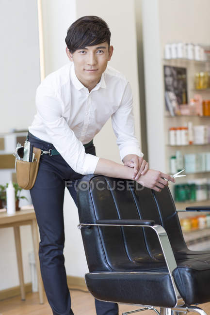 Chinese hairdresser in barber shop looking in camera — Stock Photo