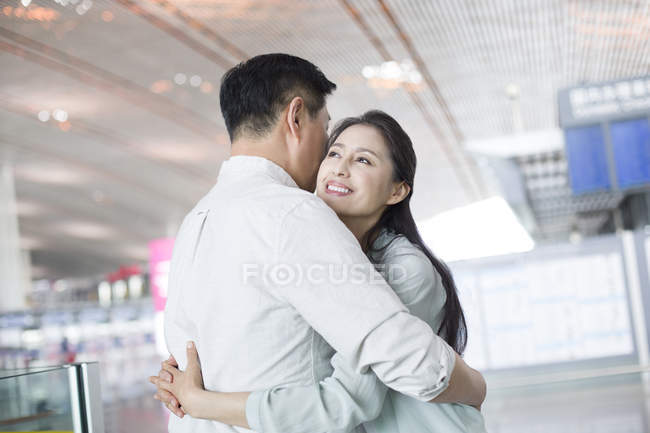Maduro chino pareja reuniéndose en el aeropuerto - foto de stock