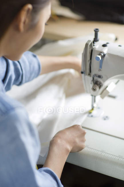 Chinese female tailor using sewing machine — Stock Photo