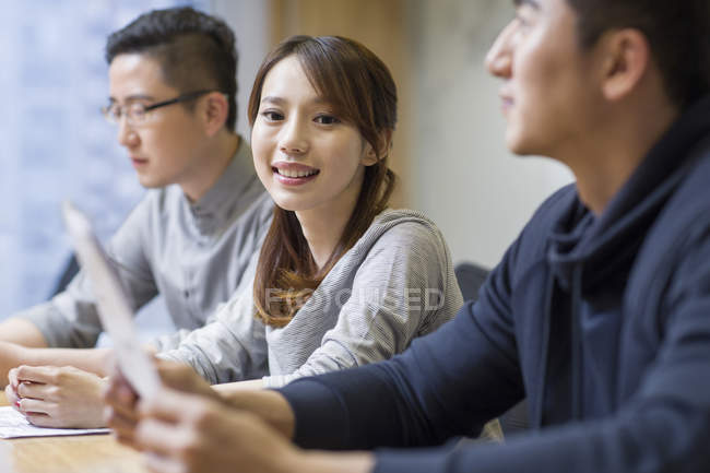 Китайська жінка, посміхаючись на зустрічі з колегами в Раду номерів — стокове фото