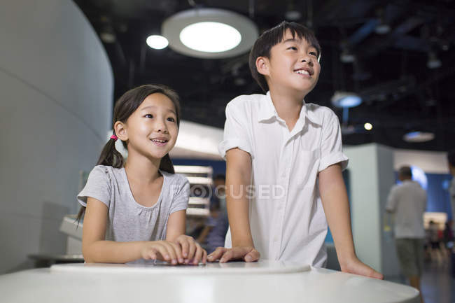 Chinese children sitting at table in museum — Stock Photo