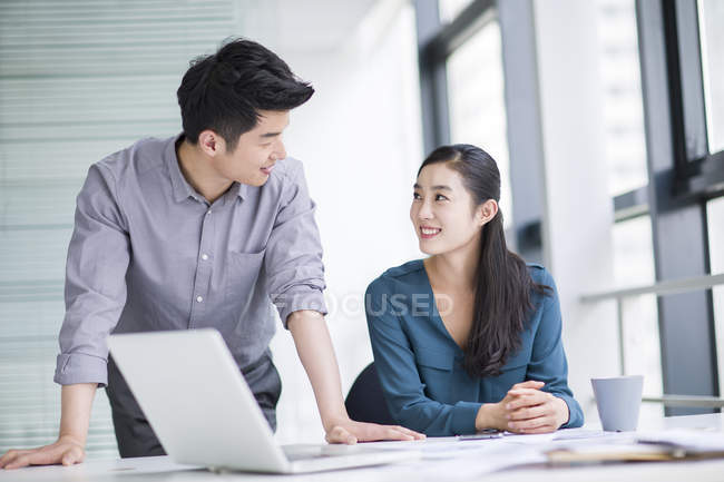 Chinese business co-workers talking in office — Stock Photo