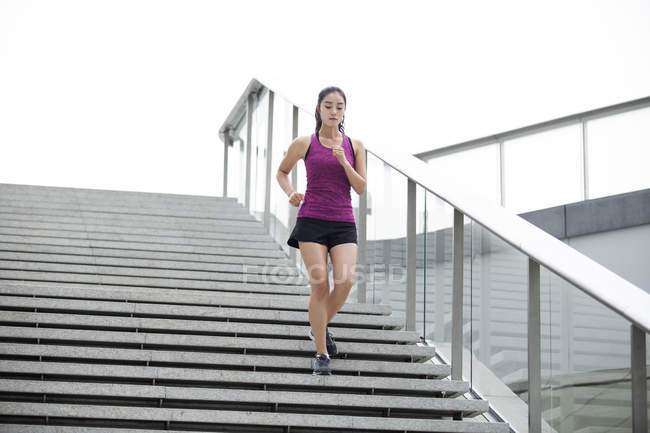 Chinese woman running down on stairs — Stock Photo