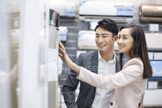 Couple chinois achetant climatiseur dans un magasin d'électronique — Photo de stock