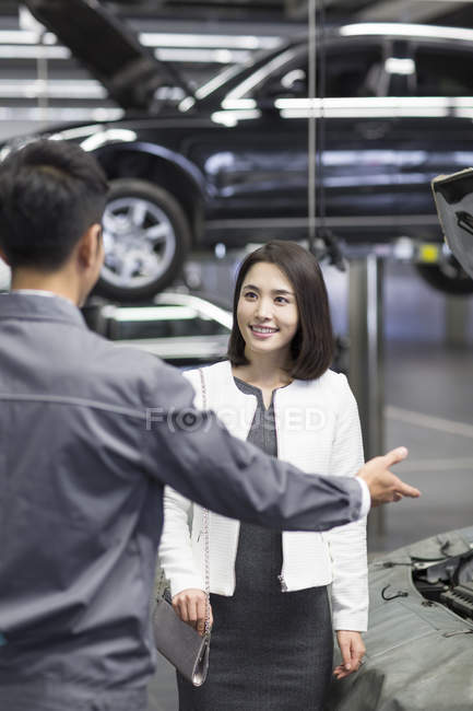 Chinês mecânico de automóveis falando com o proprietário do carro — Fotografia de Stock