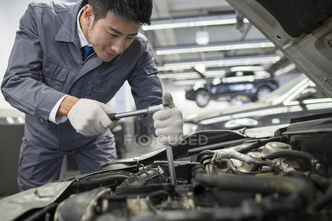 Chinese auto mechanic working in repair shop — Stock Photo