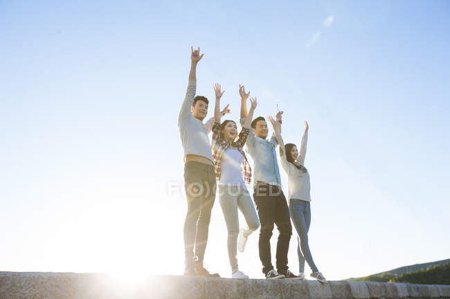 Chinese friends standing on lakeside in suburbs — Stock Photo