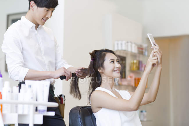 Cliente chino tomando selfie en peluquería - foto de stock