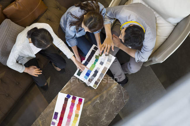Chinese fashion designers looking at textile samples in studio — Stock Photo