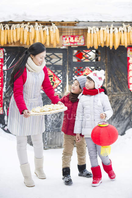 Mère et frères et sœurs avec des boulettes chinoises traditionnelles dans le village — Photo de stock