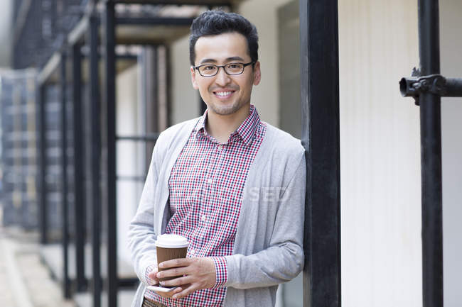 Homem chinês segurando xícara de café — Fotografia de Stock