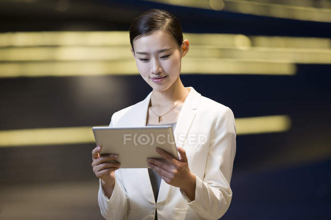 Donna d'affari cinese che utilizza tablet digitale sulla strada — Foto stock