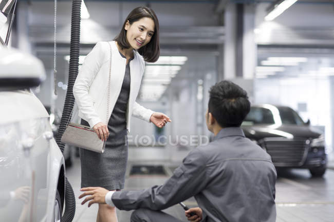 Chinesischer Automechaniker im Gespräch mit Autobesitzer — Stockfoto