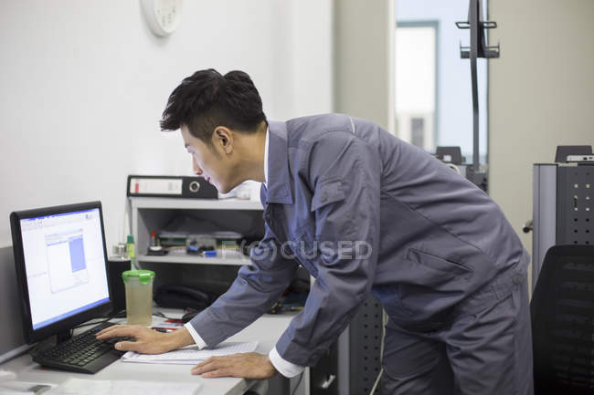 Chinese auto mechanic working with computer — Stock Photo