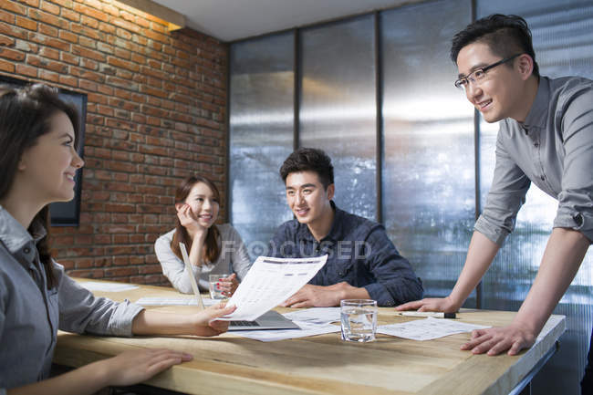 Colegas chinos discutiendo trabajo en sala de reuniones - foto de stock