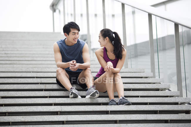 Китайская пара отдыхает на лестнице после тренировки — стоковое фото