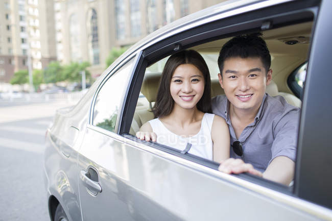 Chinese couple sitting on car back seat — Stock Photo