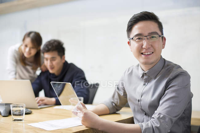Lavoratore IT maschio seduto con modello di tablet digitale in sala riunioni — Foto stock