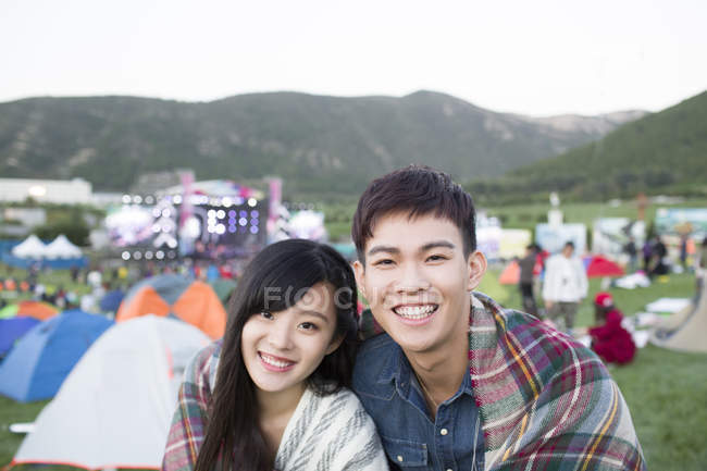 Chinesisches Paar in Decke gehüllt umarmt sich auf Festival-Campingplatz — Stockfoto
