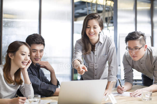 Travailleurs chinois assis à la salle de réunion avec ordinateur portable — Photo de stock