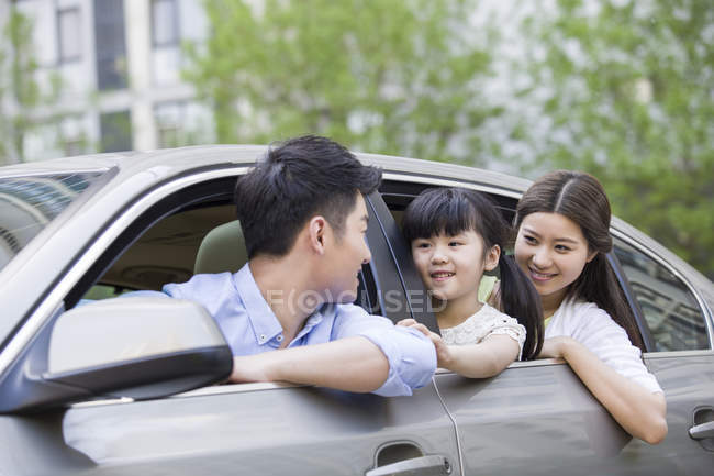 Chinese family riding and leaning out of car — Stock Photo