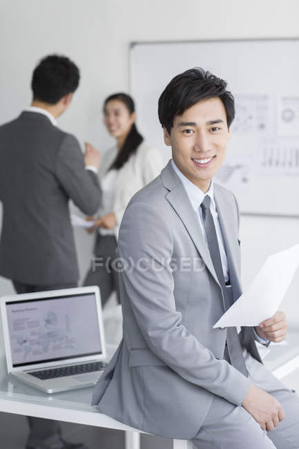Chinese businessman sitting with papers — Stock Photo