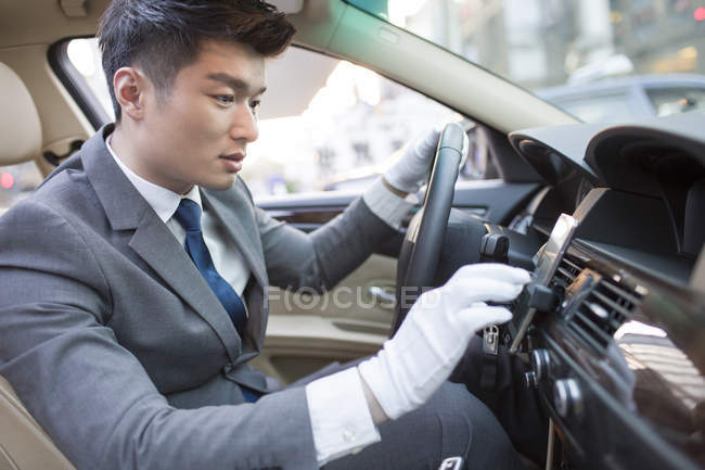 Китайский шофер использует смартфон в автомобиле — стоковое фото