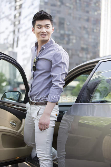 Chinese man getting out of car — Stock Photo