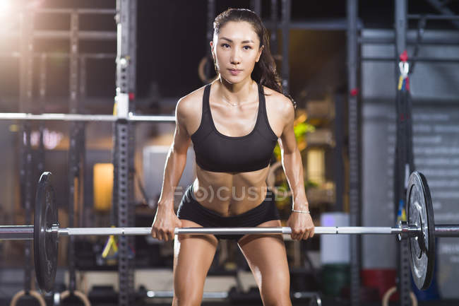 Chinesin hebt Langhantel im Fitnessstudio — Stockfoto