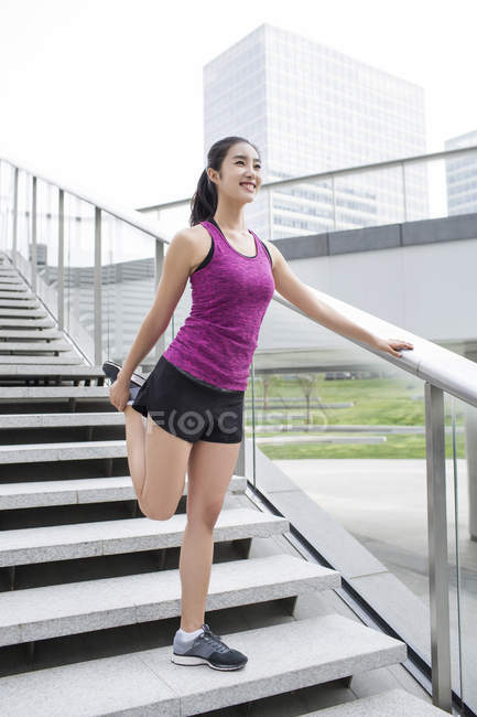 Femme chinoise étirant sur les escaliers de la rue — Photo de stock