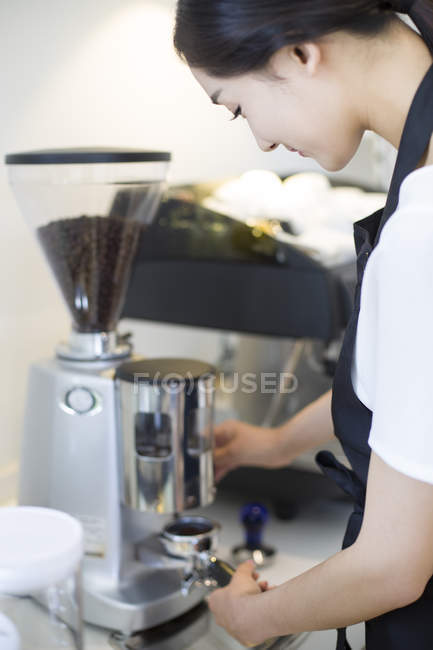 Chinese barista making coffee in cafe — Stock Photo