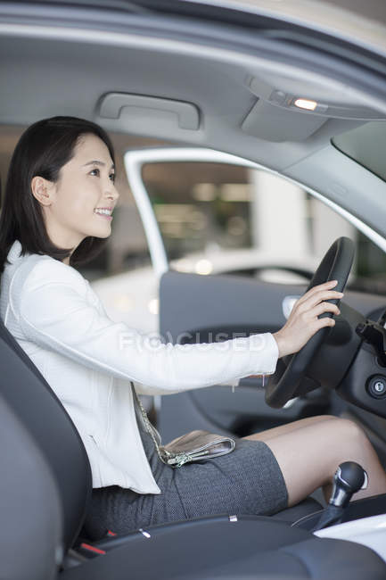 Jeune femme chinoise assise dans la voiture — Photo de stock
