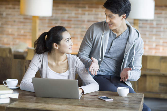 Chinesische Studenten im Gespräch mit Laptop im Café — Stockfoto