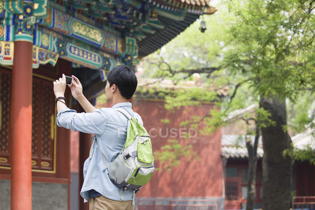 Uomo cinese che scatta foto con smartphone nel Tempio di Lama — Foto stock