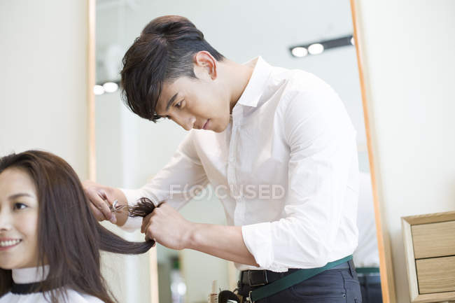 Chinese barber cutting female customer hair — Stock Photo