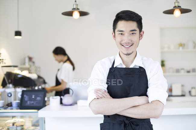 Chinês dono da loja de café de pé com braços dobrados — Fotografia de Stock