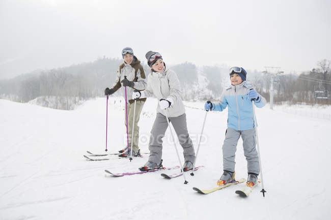 Китайская семья с сыном катается на лыжах на горнолыжном курорте — стоковое фото