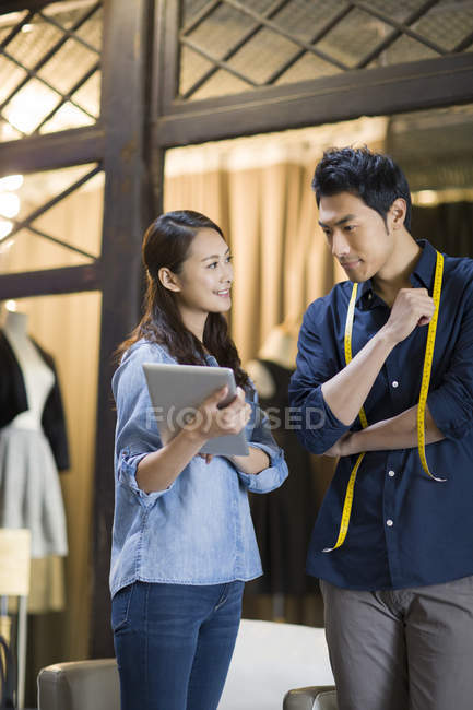 Chinese fashion designers using digital tablet in studio — Stock Photo