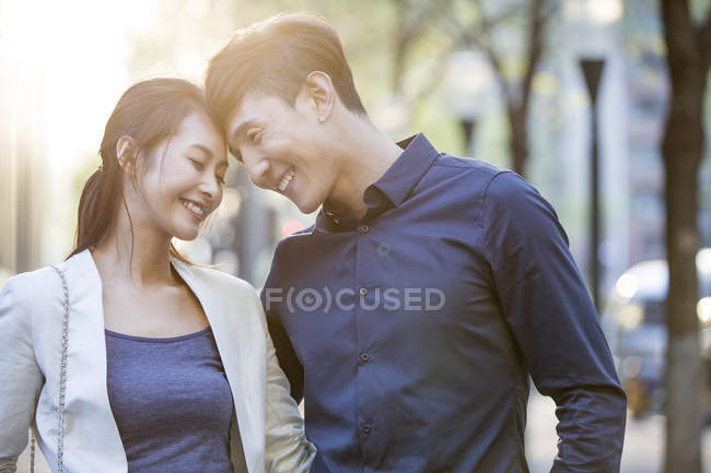 Chinese couple touching foreheads on street — Stock Photo