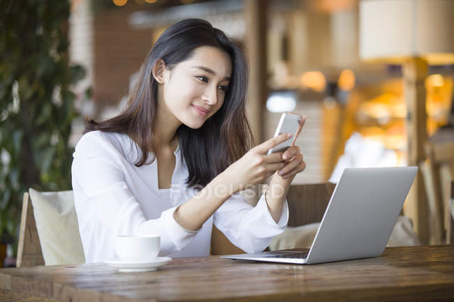Donna cinese utilizzando smartphone in caffè — Foto stock