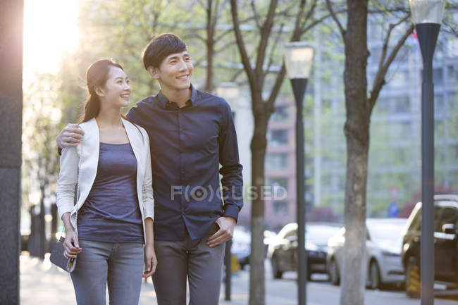 Cinese coppia a piedi sul marciapiede in città e guardando altrove — Foto stock