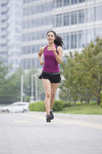 Chinese woman running on street — Stock Photo