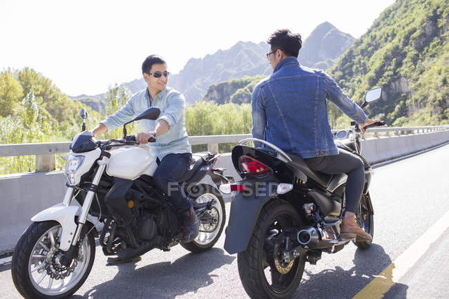 Chinese friends sitting on motorcycles together — Stock Photo