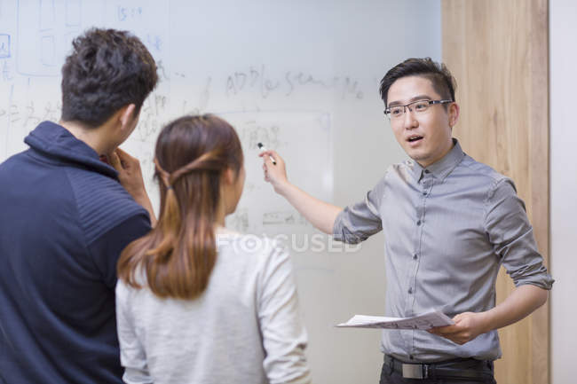 Travailleurs informatiques chinois ayant une réunion dans la salle de conseil — Photo de stock