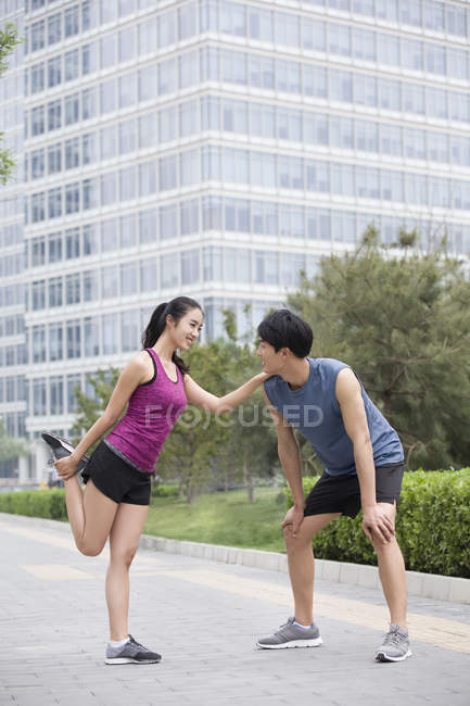Casal chinês exercitando juntos na rua — Fotografia de Stock