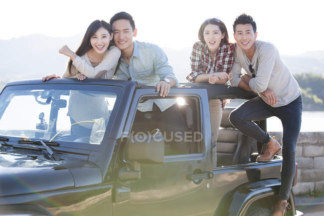 Китайские друзья сидят в машине и смотрят в камеру — стоковое фото