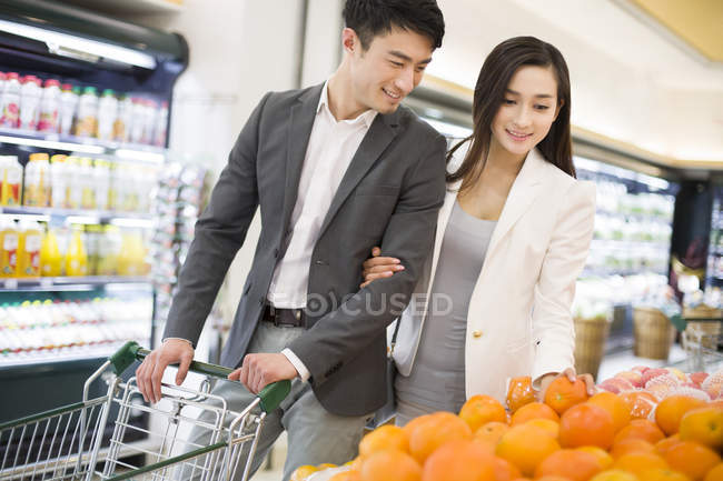 Casal chinês comprando frutas no supermercado — Fotografia de Stock