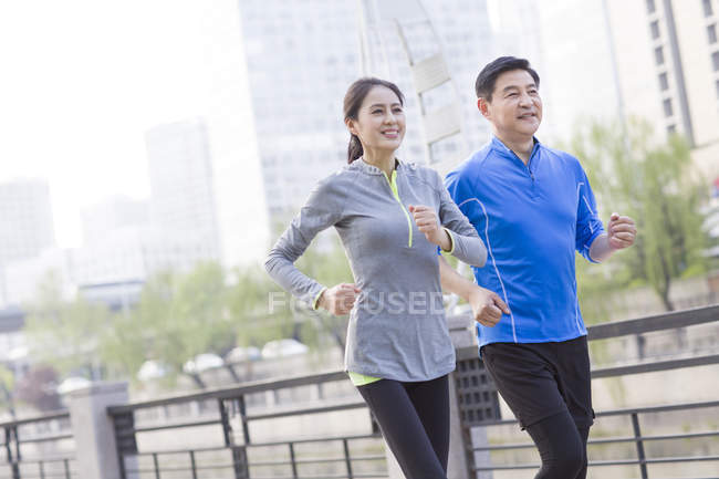 Взрослая пара из Китая бегает по городу — стоковое фото