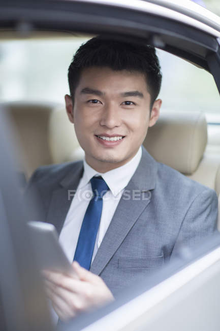 Chinesischer Geschäftsmann sitzt auf Rücksitz im Auto — Stockfoto